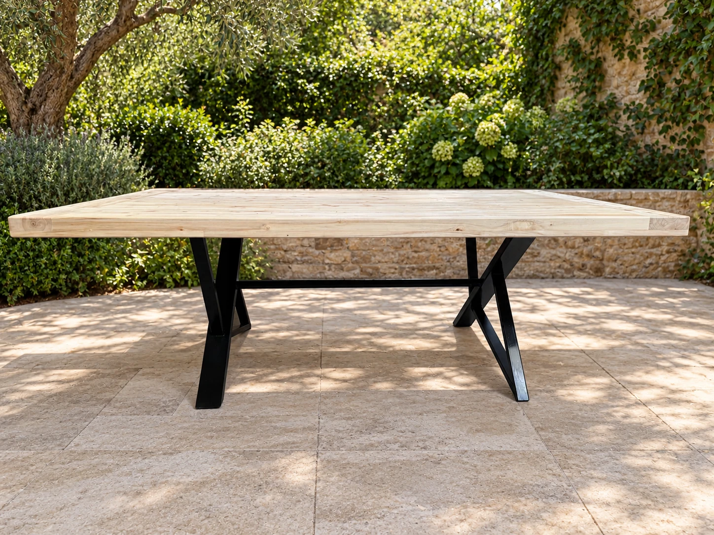 Mesa Calandria de álamo con base de chapa negra en Z, frente a un jardín
